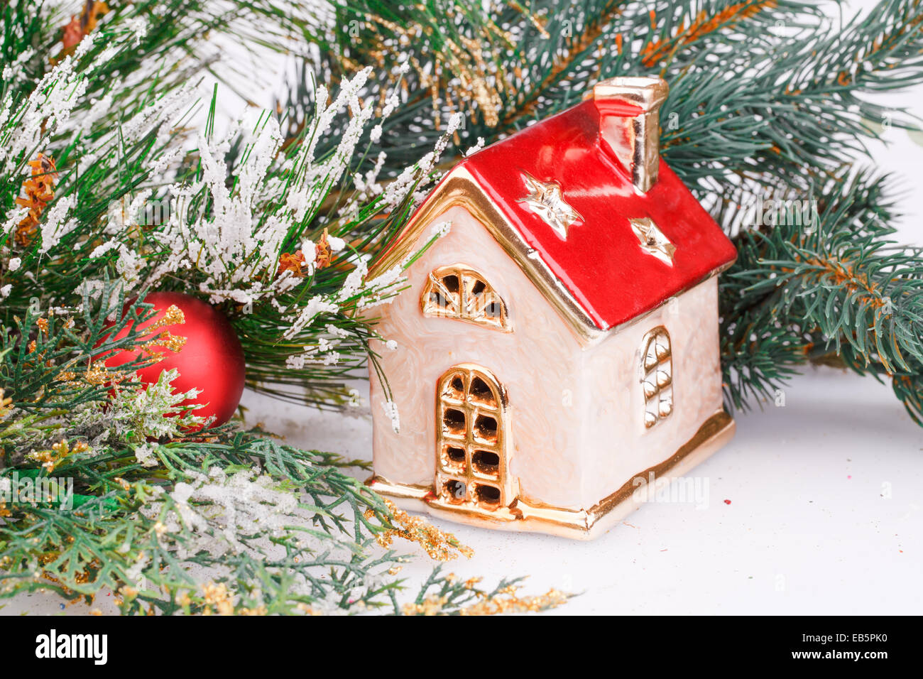 Decorazione di natale con sfera rossa, fir-ramo di albero e casa del giocattolo. Foto Stock