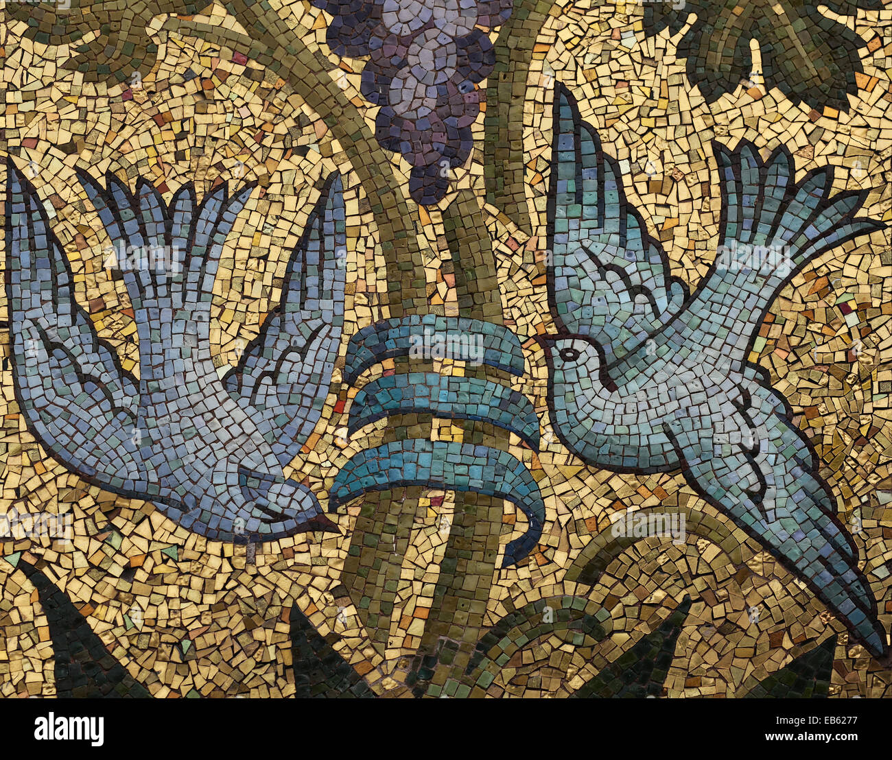 Due piccioni battenti intorno a un vitigno. Mosaico di vetro colorato smalts sulla terra dorata. La Scuola Mosaicisti del Friuli, Spilimbergo, Italia. Foto Stock