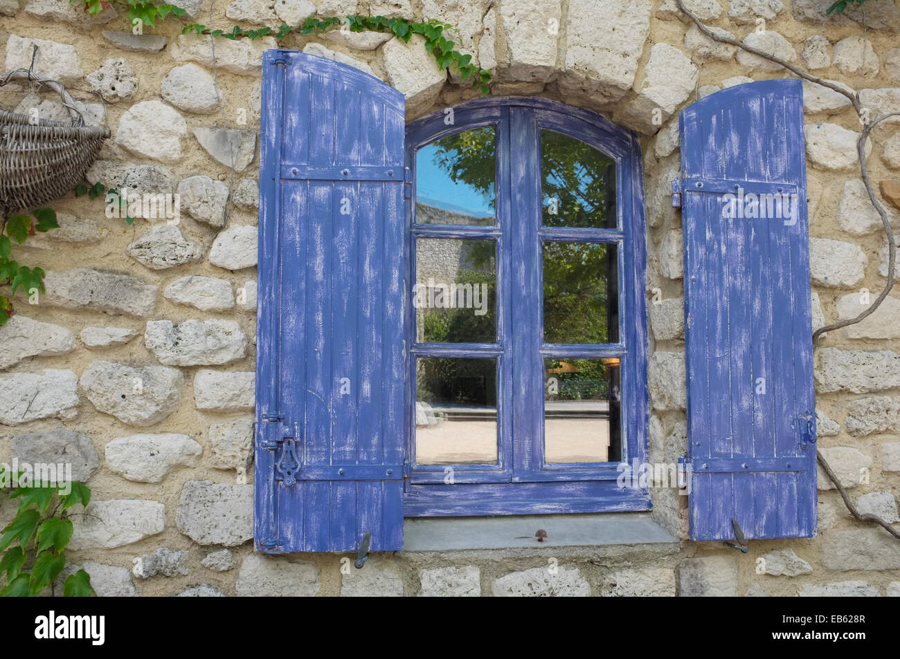In stile provenzale, blu lavanda persiane alle finestre in La Garde-Adhémar, Drôme, Francia. Foto Stock