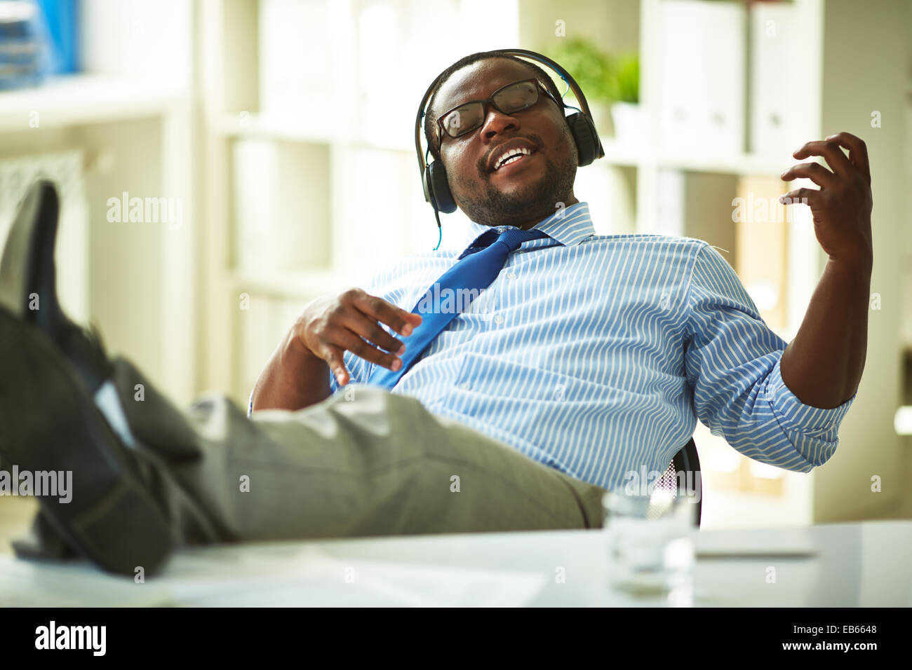 Imprenditore in seduta le cuffie in ufficio Foto Stock