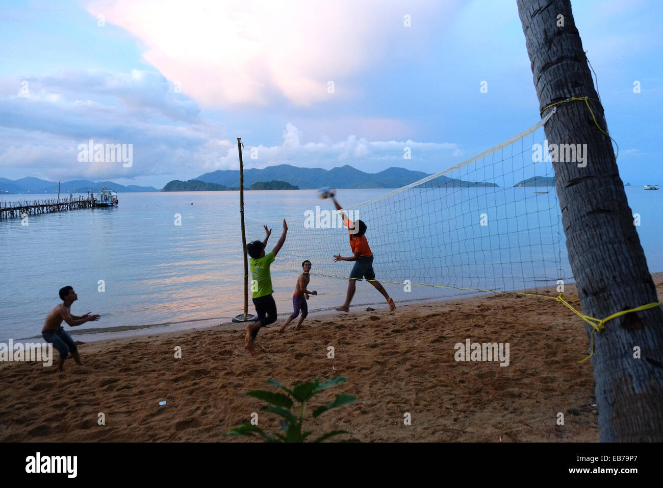 Koh Wai, della Thailandia . 27 Nov, 2014. A Pakarang Beach, Koh Wai. La gente del posto giocando a pallavolo al tramonto. Centinaia ogni giorno visita ma pochi pernottamento sull'isola. Numero di turisti verso il basso dal visitatore tradizionali paesi, sebbene aumentare da Cina e Russia. Il primo ministro, un uomo militare inserito dopo il colpo di stato, ha annunciato che le elezioni non può essere mantenuto fino al 2016. Annuncio on line campagna per aumentare il numero di visitatori " Io odio questo paese' va virale. Credito: Paolo Quayle/Alamy Live News Foto Stock