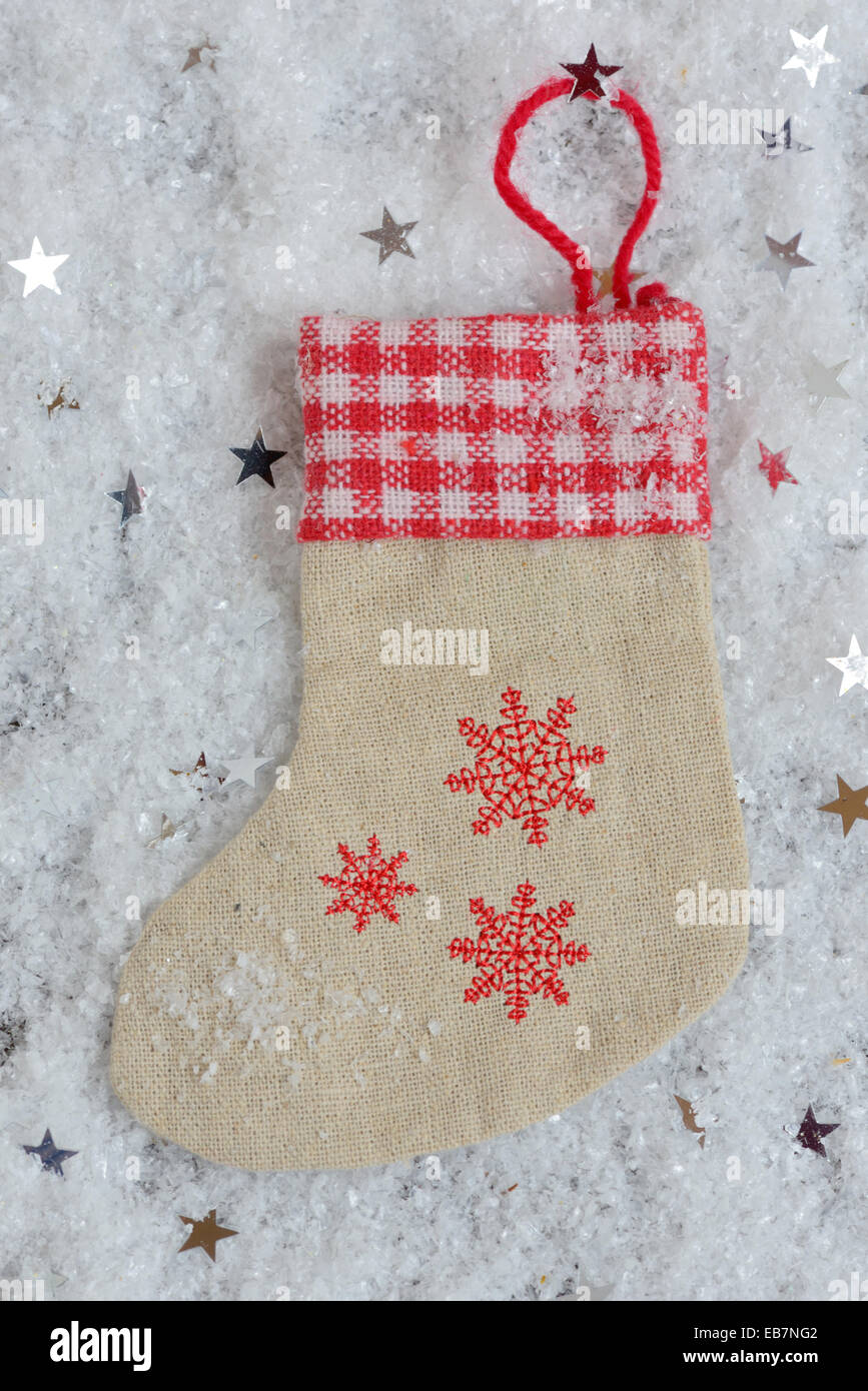 Calza con i fiocchi di neve per Santa doni su sfondo di neve Foto Stock