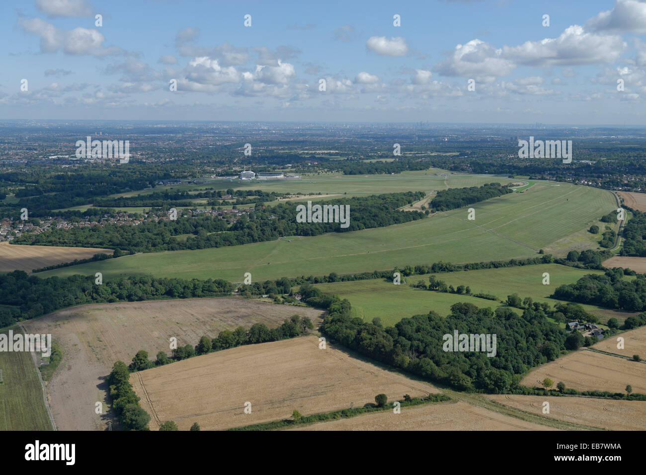 Una veduta aerea di Epsom Downs con l'ippodromo visibile e gli alti edifici di Londra in distanza Foto Stock