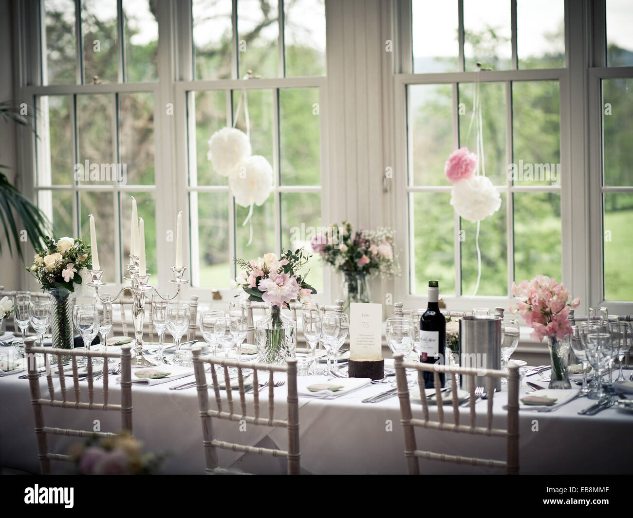 La prima colazione di nozze tabella superiore impostazioni con fiori e vino Foto Stock