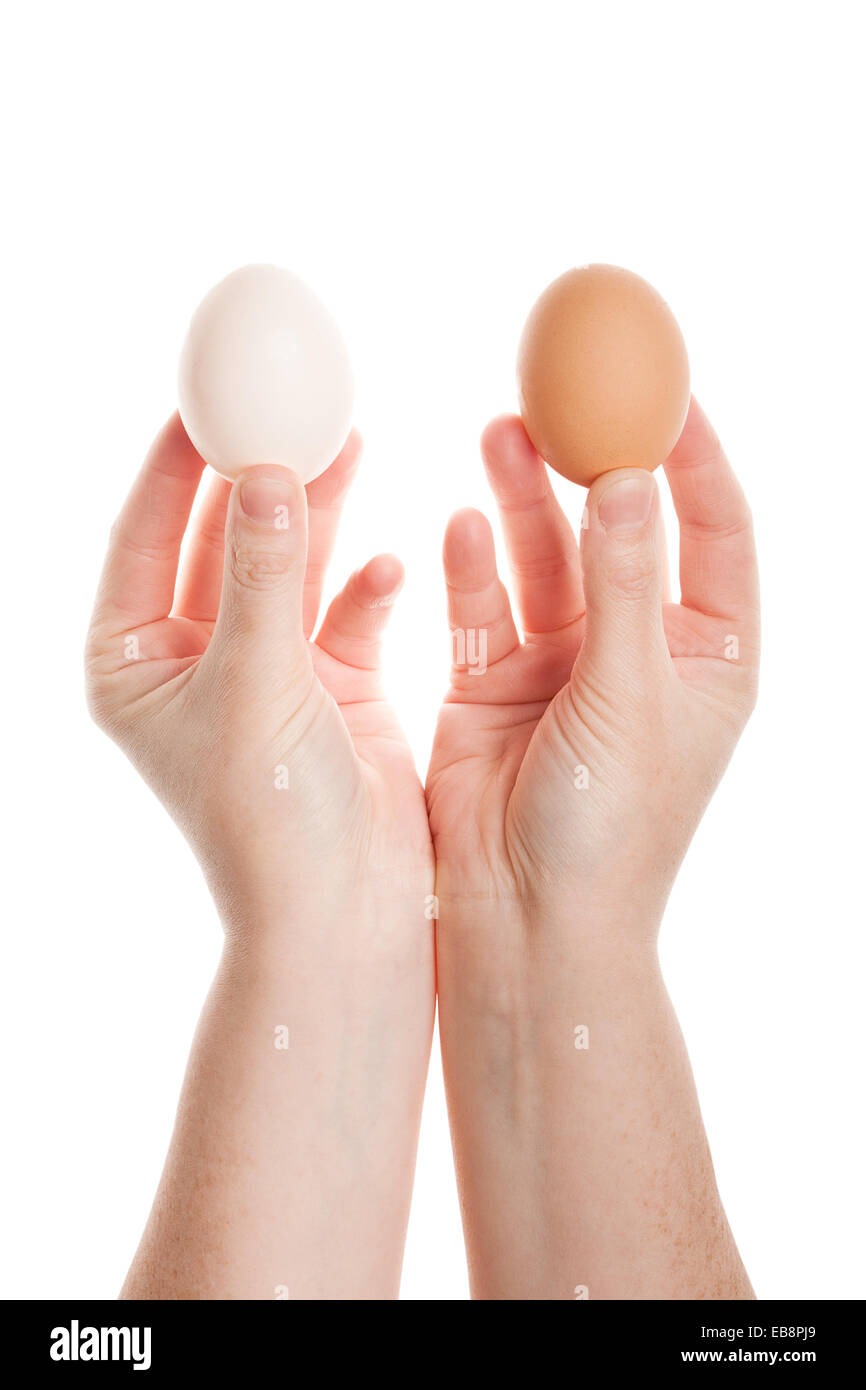 Mani femminili con due uova isolate su sfondo bianco Foto Stock