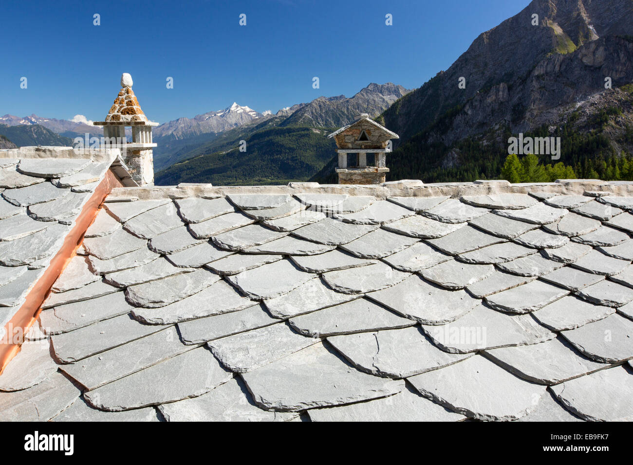Grandi lastre di roccia su un tetto di casa al di sopra di Courmayeur, Italia. Foto Stock