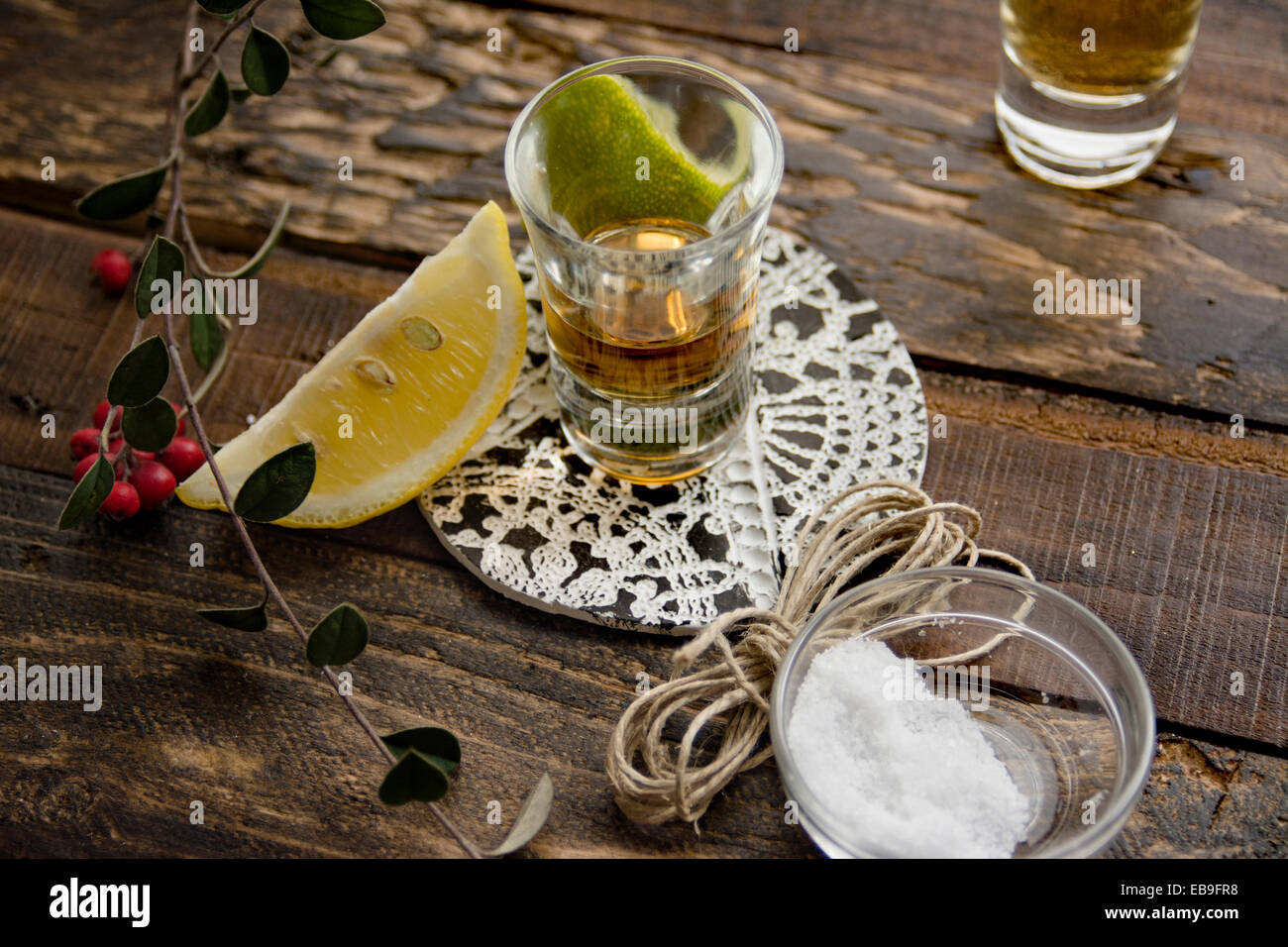 Scatti di tequila, limone calce e sale su uno sfondo di legno Foto Stock