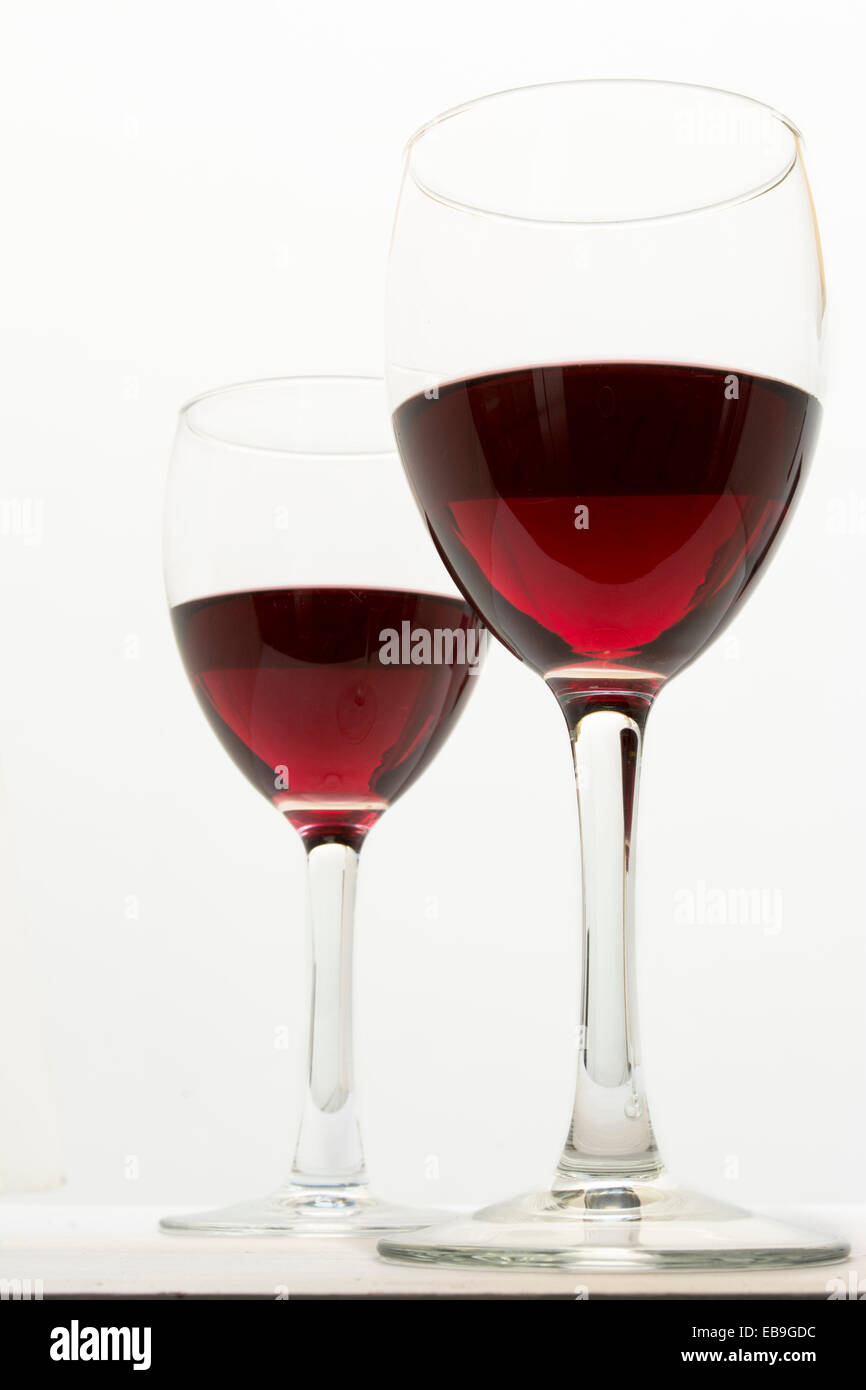 Due bicchieri di vino rosso, liquido dettagli su sfondo bianco Foto Stock