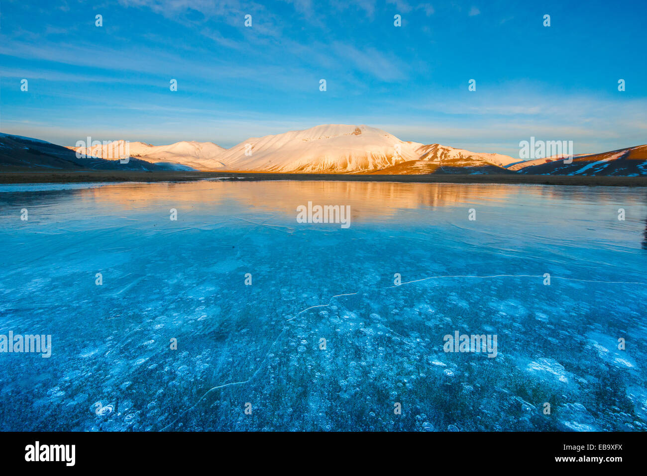 Monte Vettore nella luce della sera con una pozzanghera congelata con bolle di aria, Parco Nazionale dei Monti Sibillini, Umbria, Italia Foto Stock