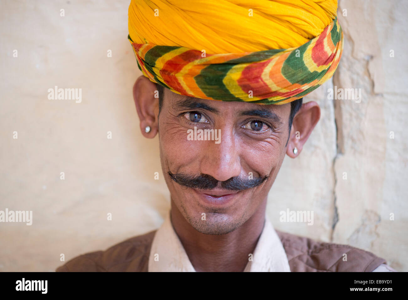 Servo indossando un turbante giallo e orecchini, ritratto, Forte Mehrangarh, Jodhpur, Rajasthan, India Foto Stock