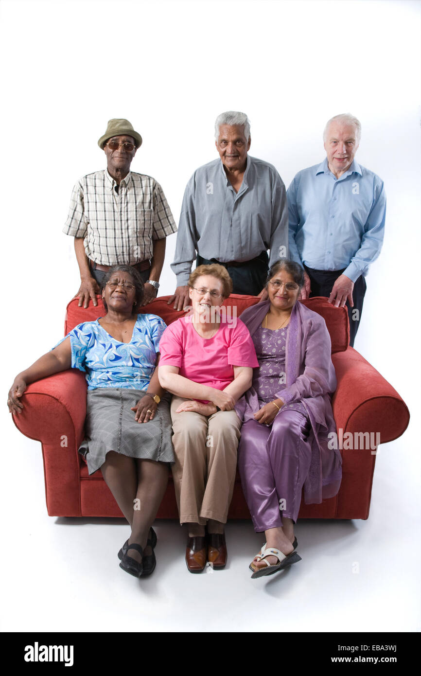 Gruppo multirazziale delle persone anziane seduto su un divano insieme sorridente, Foto Stock
