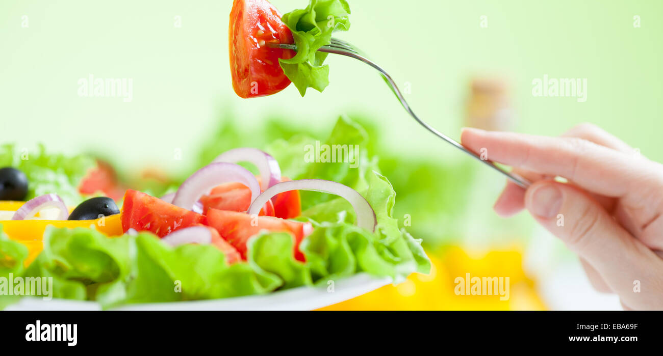 Salutare mangiare insalata di verdure su sfondo verde Foto Stock