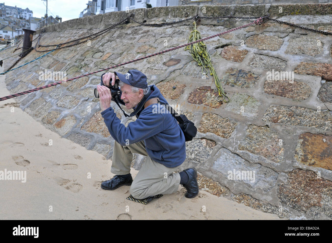 Un pensionato uomo prendendo fotografie su una spiaggia Foto Stock
