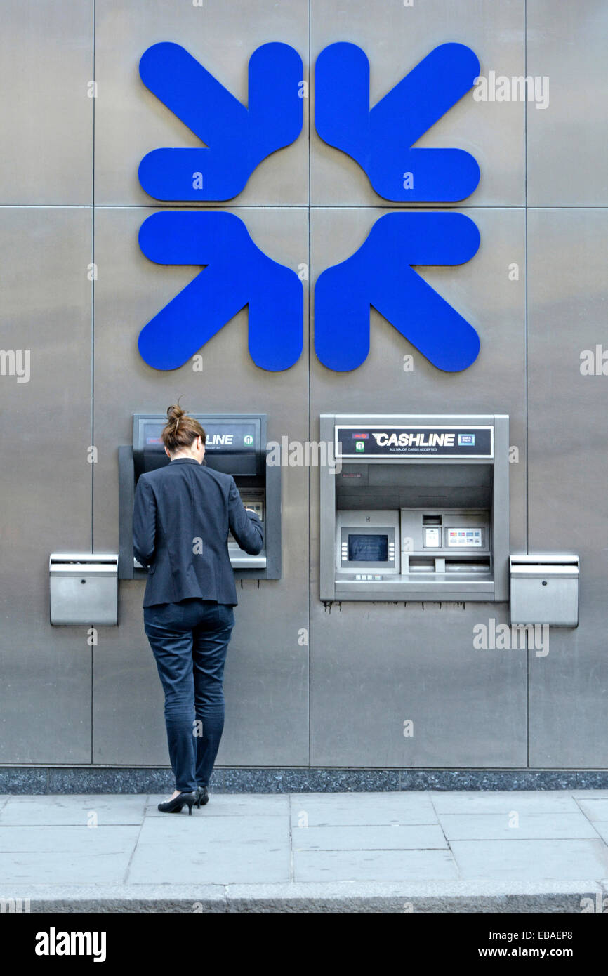 City of London donna con Royal Bank of Scotland cash dispenser con grandi dimensioni e logo aziendale sulla parete sopra Foto Stock