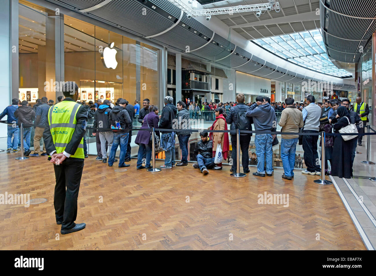 Il personale di sicurezza supervisione di controllo della folla al di fuori di Apple store nel centro commerciale Westfield Stratford Newham Est Londra Inghilterra REGNO UNITO Foto Stock