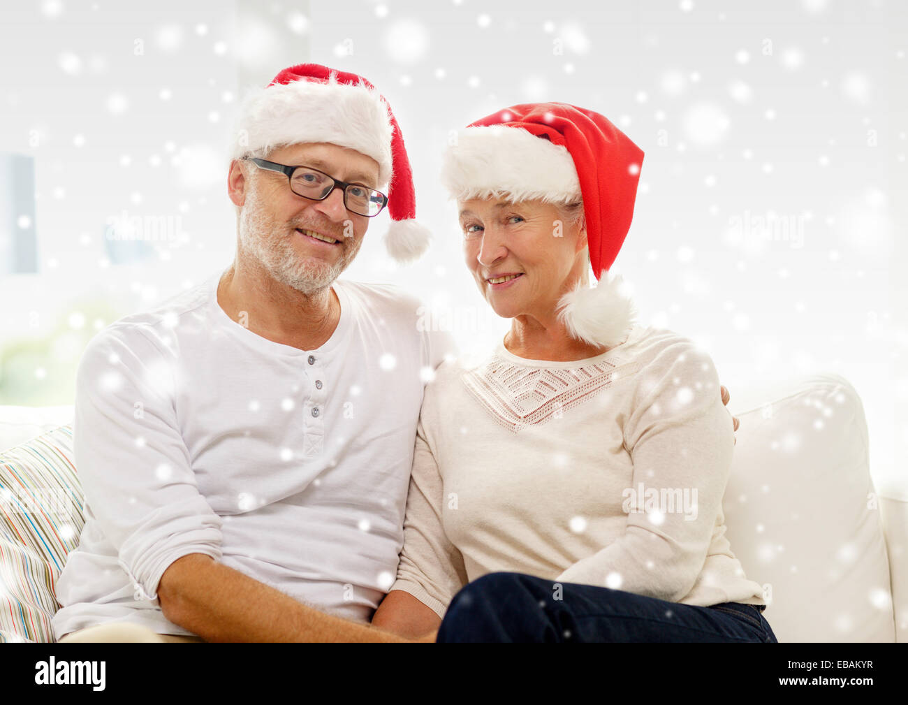 Felice coppia senior in santa helper cappelli a casa Foto Stock