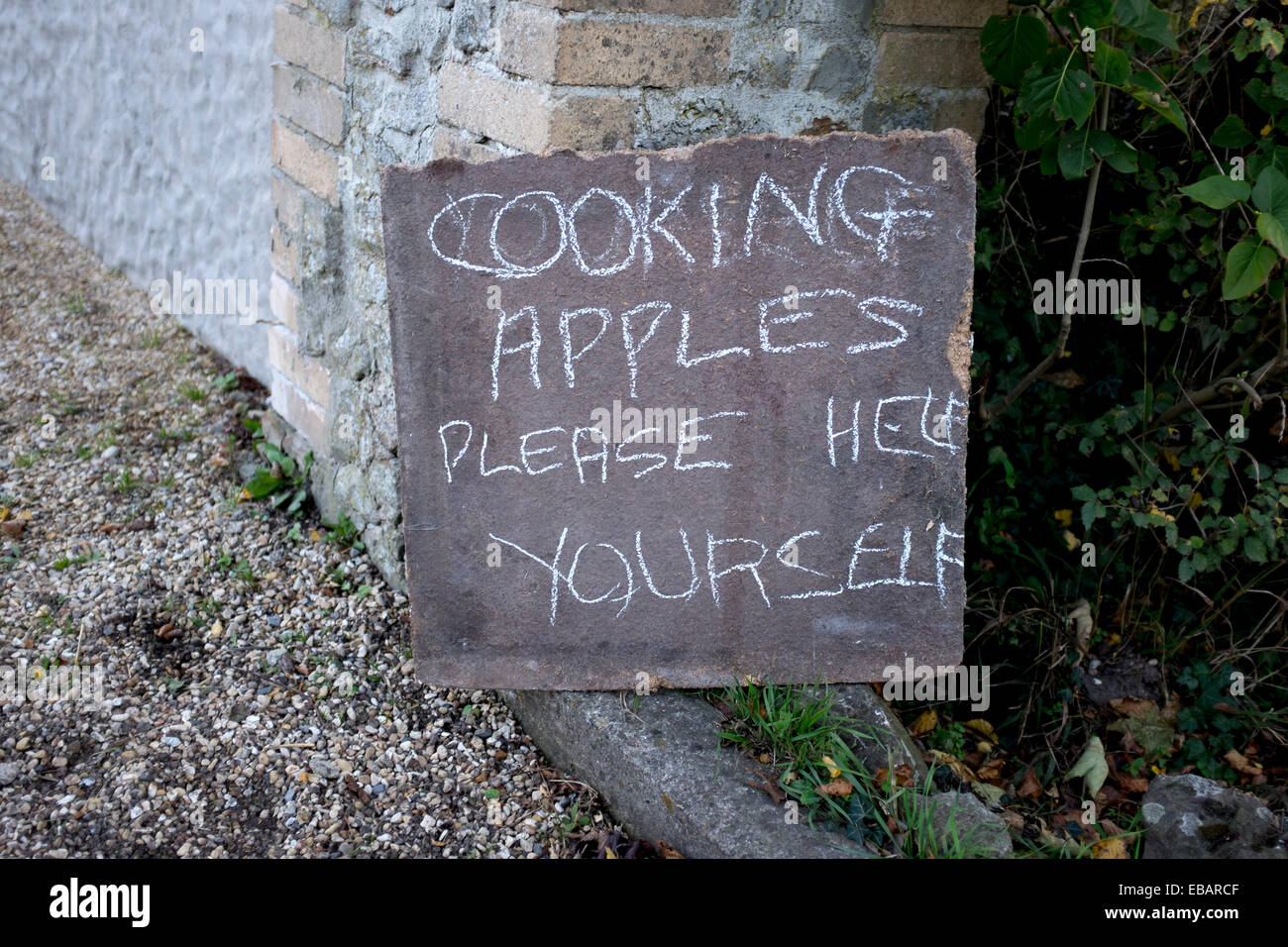 La cottura di mele si prega aiutare te stesso segno dal lato della strada nel Wiltshire Foto Stock