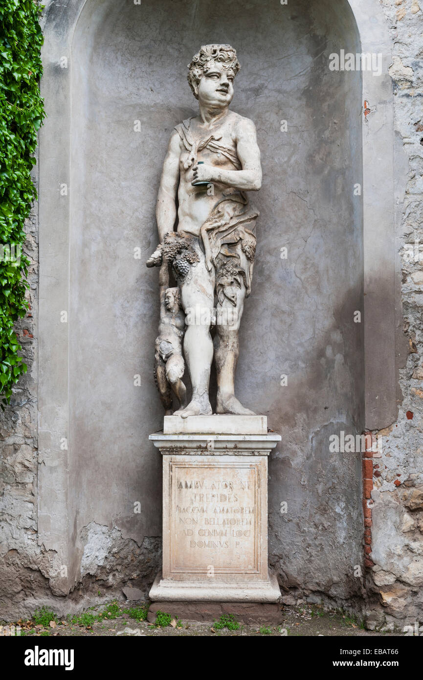 Una statua romana del dio Bacco nei giardini rinascimentali del Giardino giusti, Verona. L'iscrizione Lat lo descrive come "amante, non guerriero" Foto Stock