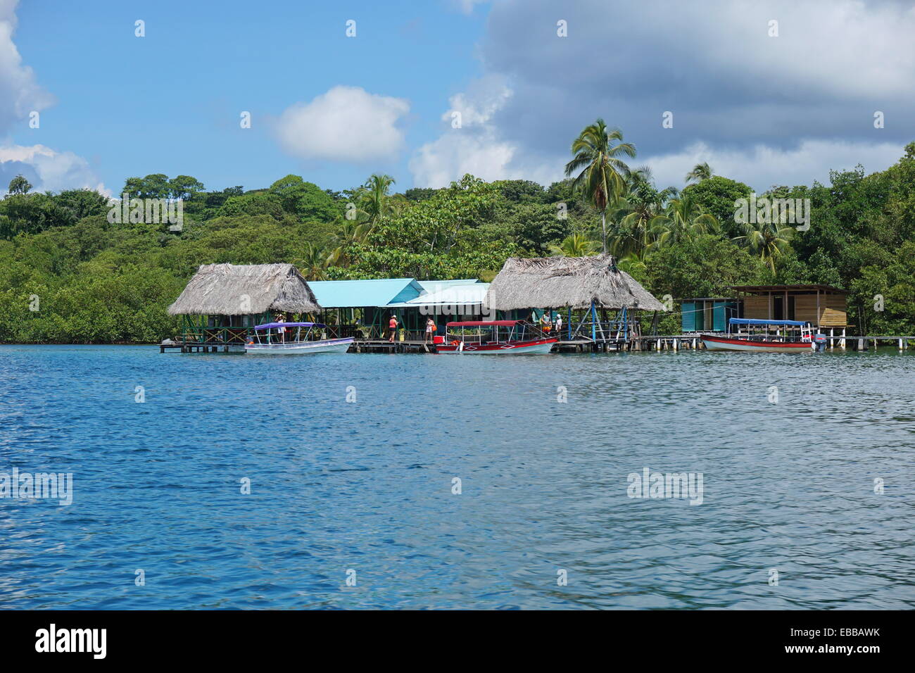 Tropical ristorante sul mare con imbarcazioni al dock e lussureggiante vegetazione, Caraibi, Bocas del Toro, America centrale e di Panama Foto Stock