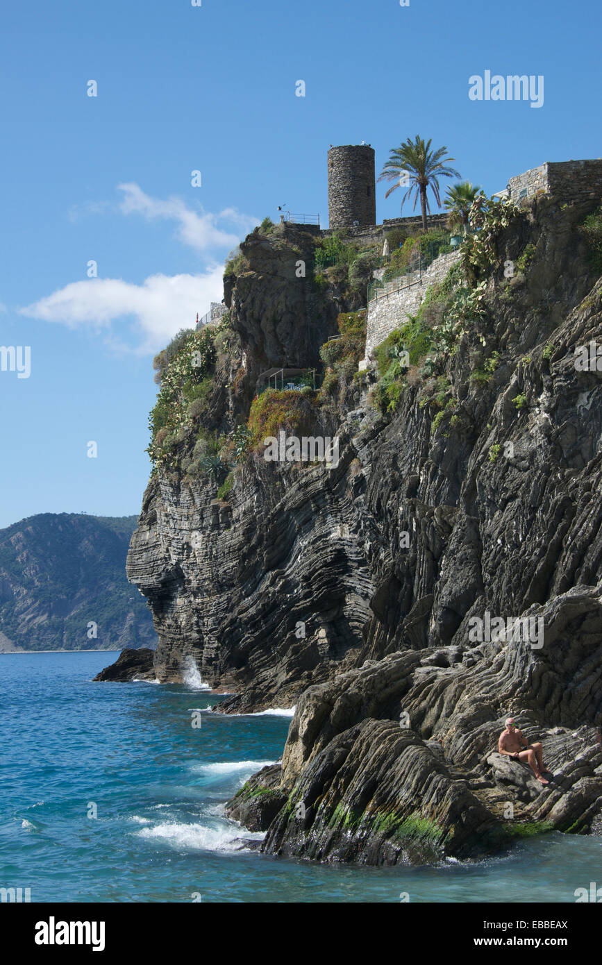 Ripiegate strati di roccia sotto medievale torre rotonda Vernazza Cinque Terre Italia Foto Stock