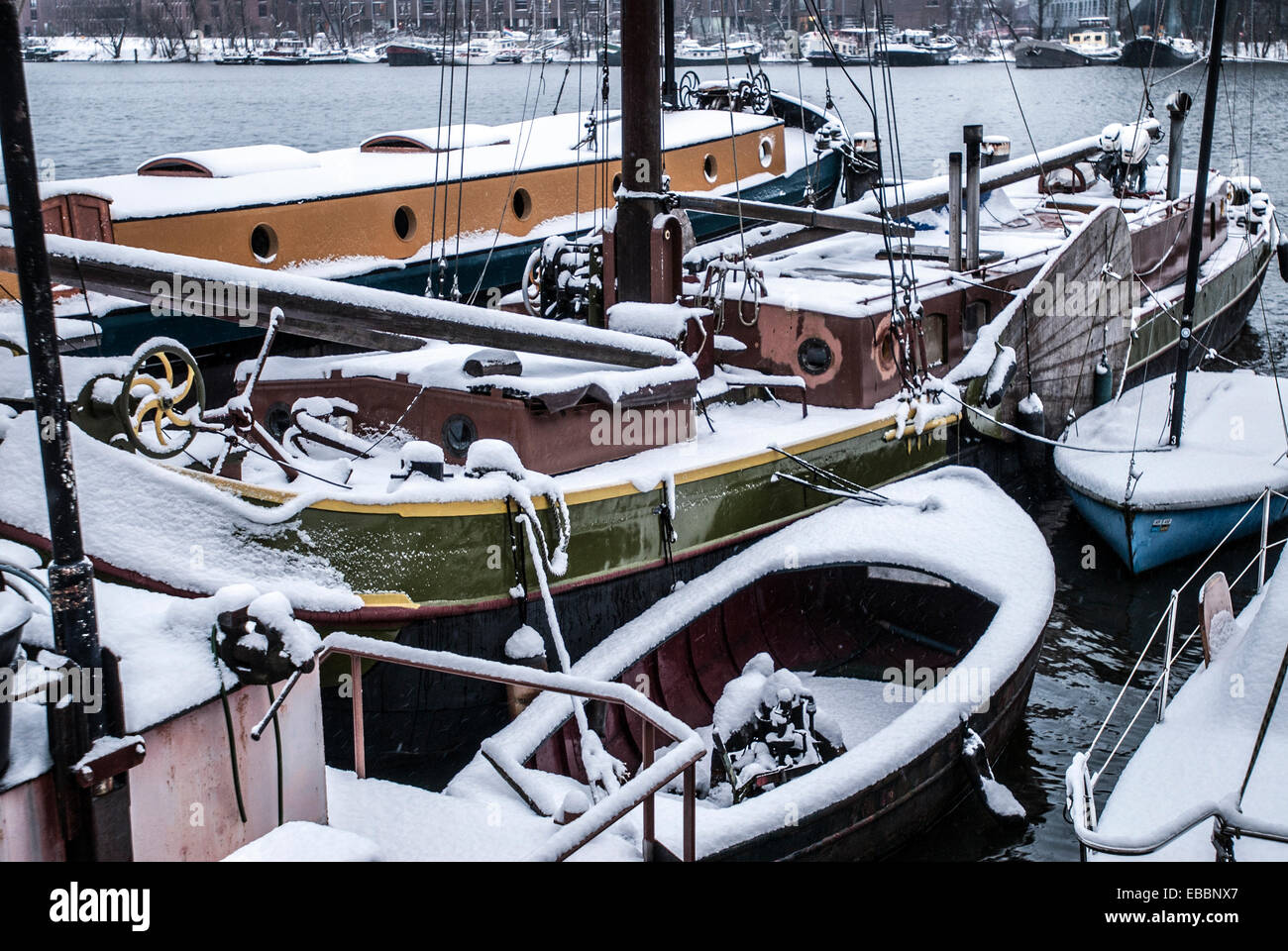 Il gruppo di case galleggianti e sloops coperte di neve nel porto di Amsterdam Foto Stock