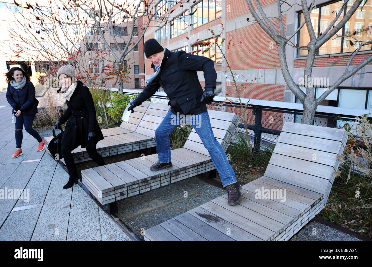 Manhattan New York Stati Uniti - l'uomo che si stupida come turisti che visitano il famoso High Line Public Park a New York l'High Line è una linea ferroviaria sopraelevata trasformata in un parco pubblico sul lato ovest di Manhattan. È di proprietà della città di New York, e gestito e gestito da Friends of the High Line. Foto Stock