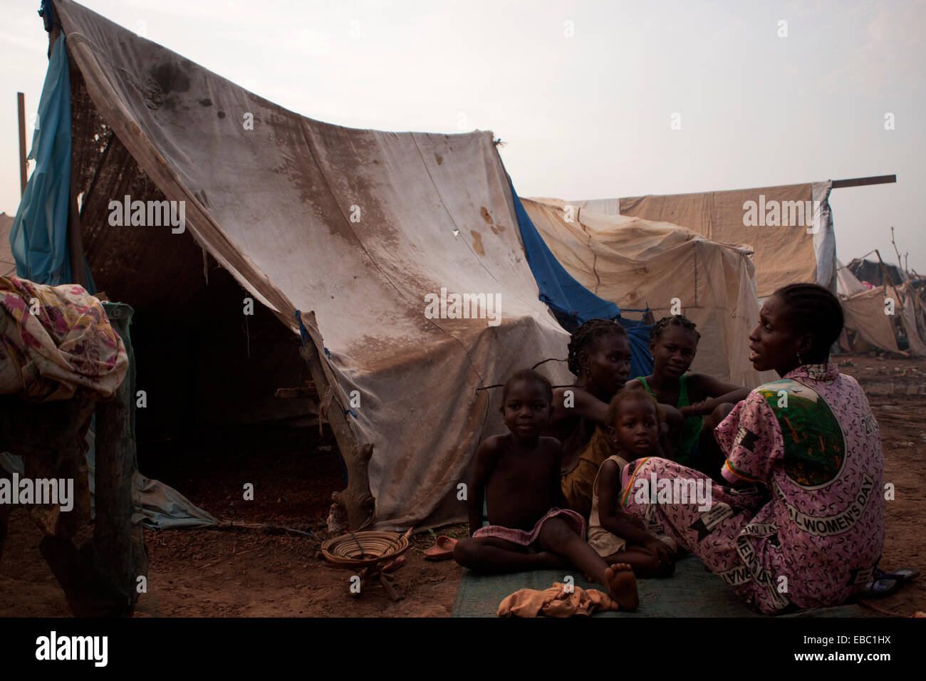 Una famiglia si trova al di fuori della loro tenda realizzato localmente in Mpoko per il campo per sfollati interni, Bangui Repubblica Centrale Africana Foto Stock