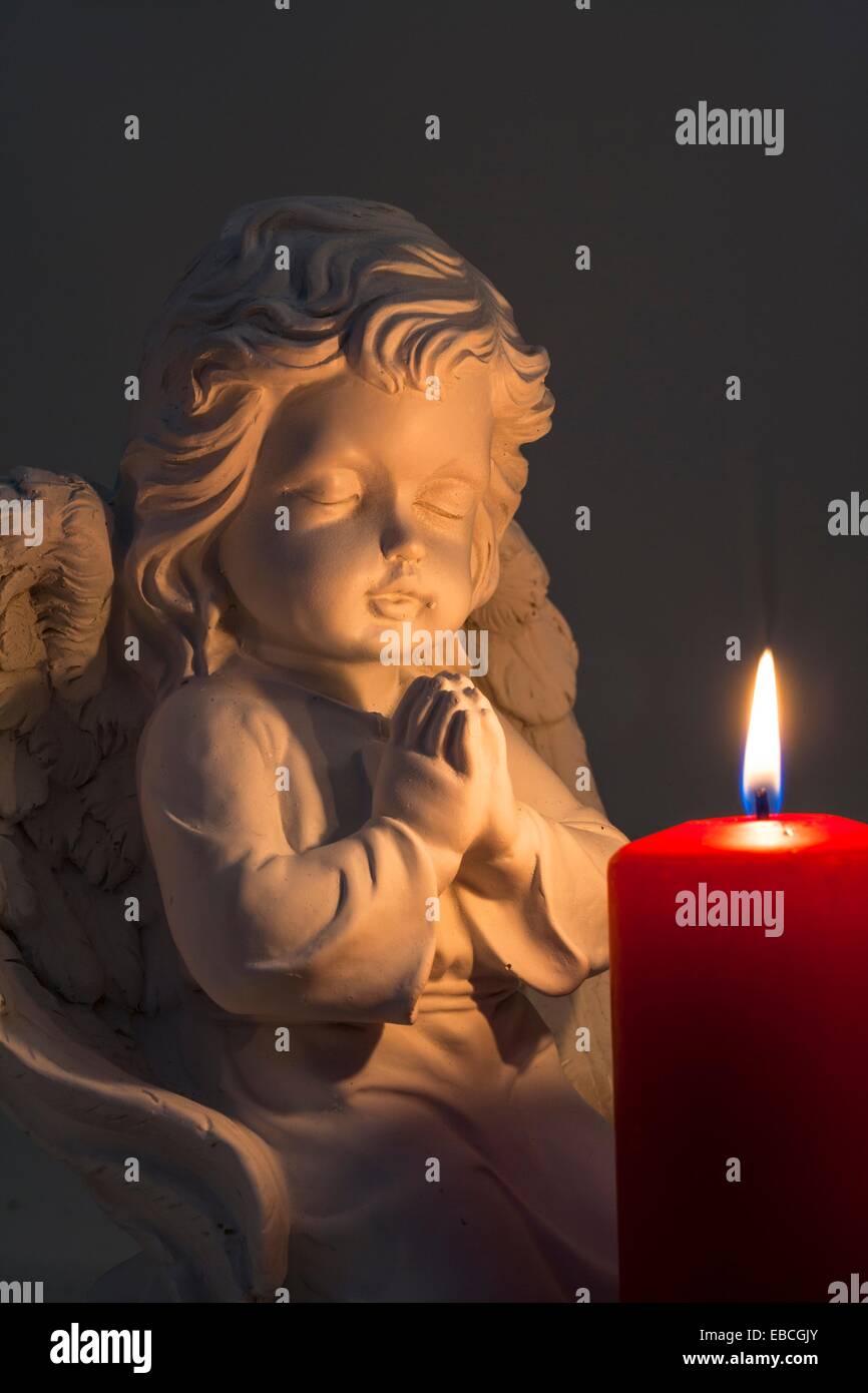 Candela accesa con una preghiera figura di angelo Foto stock - Alamy