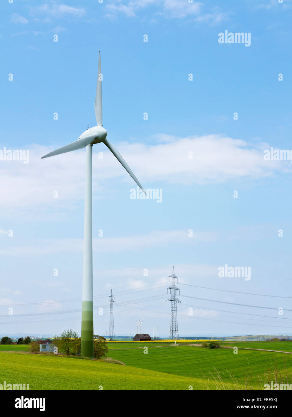Turbina eolica con alta tensione di torri di trasmissione in background, Weser colline, Renania settentrionale-Vestfalia, Germania Foto Stock