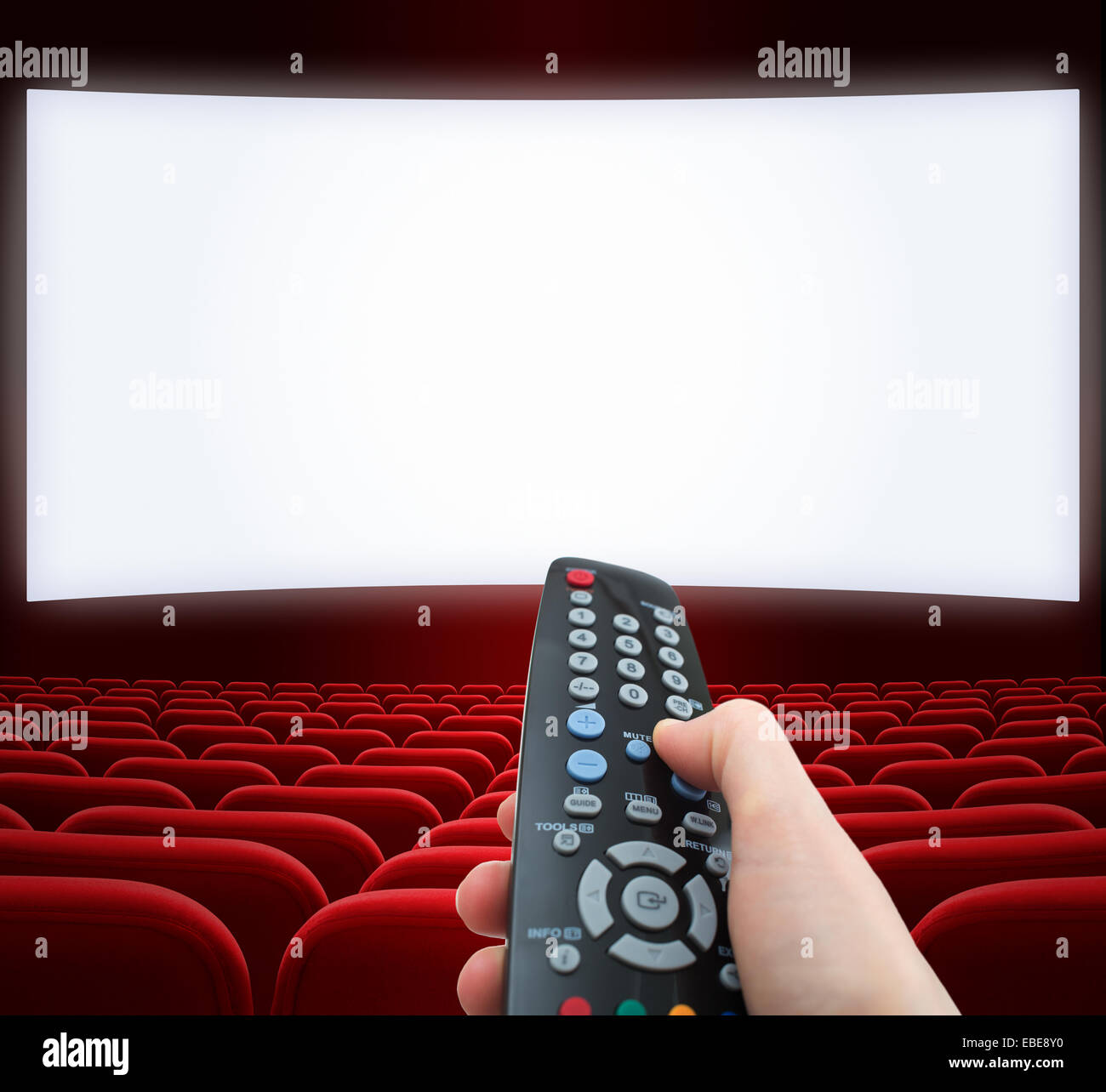 Cinema schermo con telecomando in mano Foto Stock