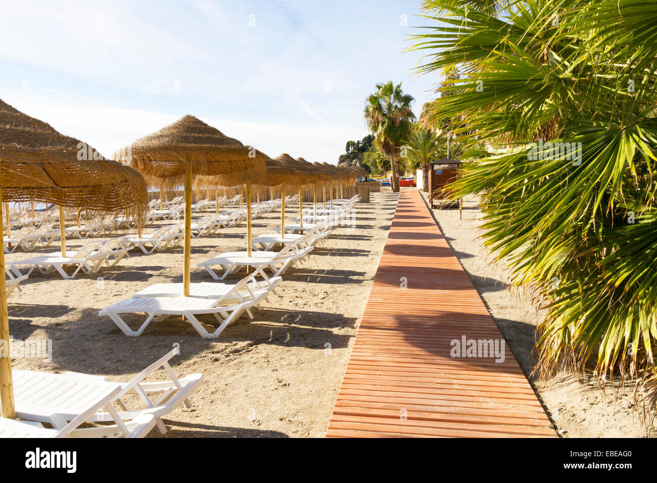 Righe vuote di lettini per prendere il sole su una spiaggia in Spagna sulla Costa del Sol Foto Stock