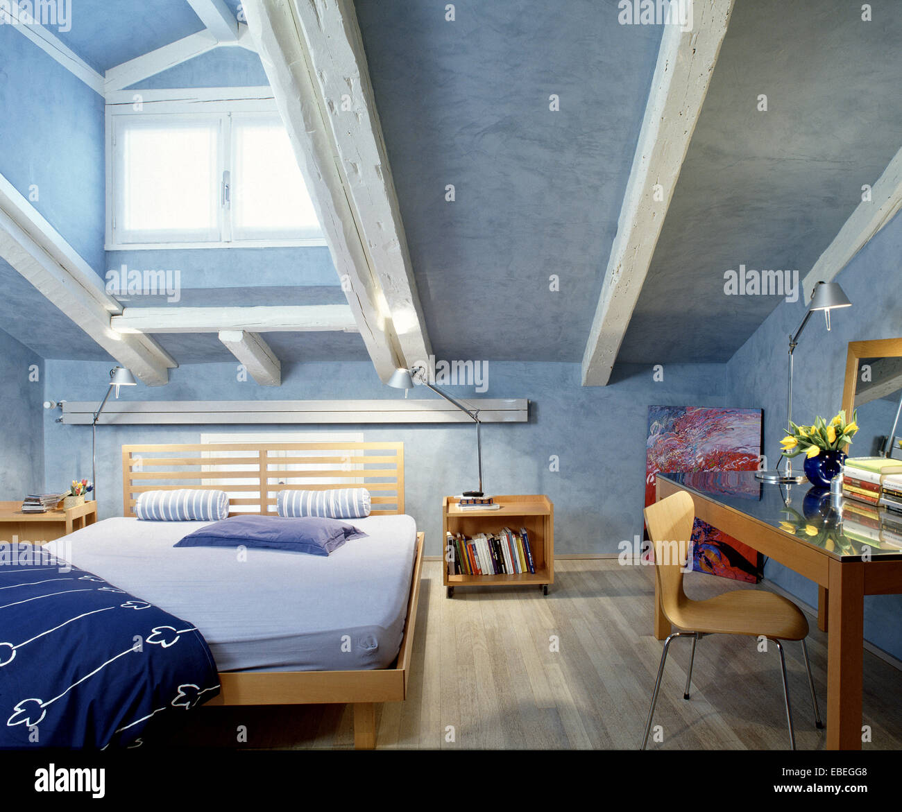 Vista interna di una moderna camera da letto in mansarda con pavimento in legno e soffitta Foto Stock