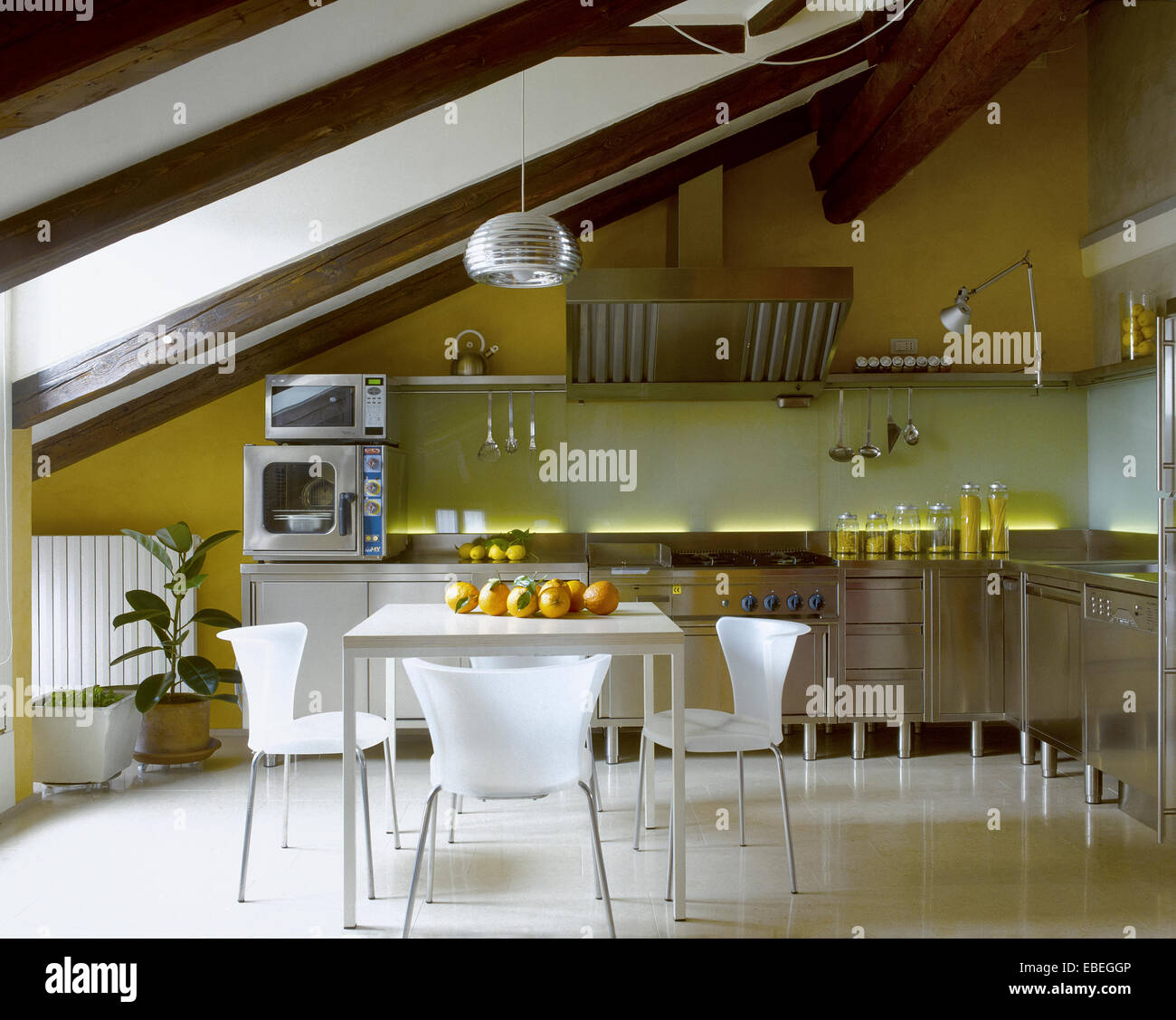 Vista interna di una cucina moderna in un attico con tavolo da pranzo Foto Stock