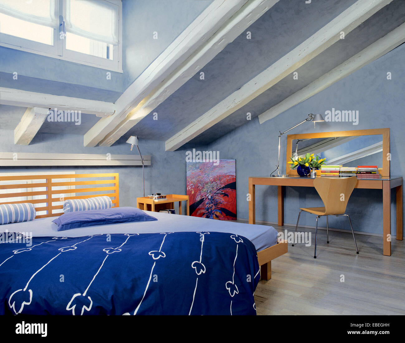 Vista interna di una moderna camera da letto in mansarda camera con pareti blu e pavimento in legno Foto Stock