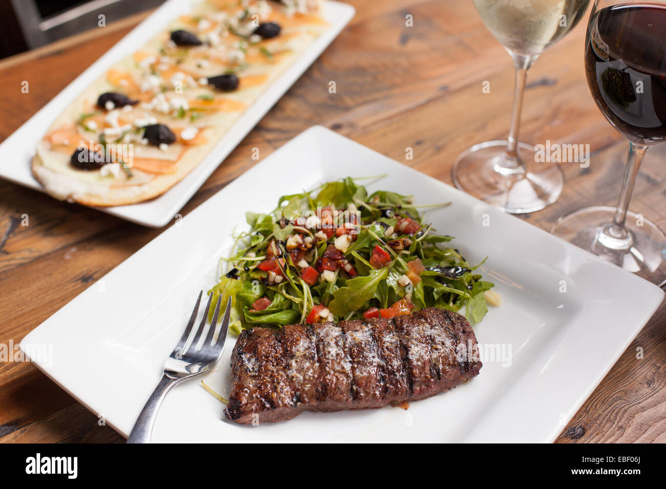 Bistecca alla griglia con insalata di rucola e rustico flatbread con il vino Foto Stock