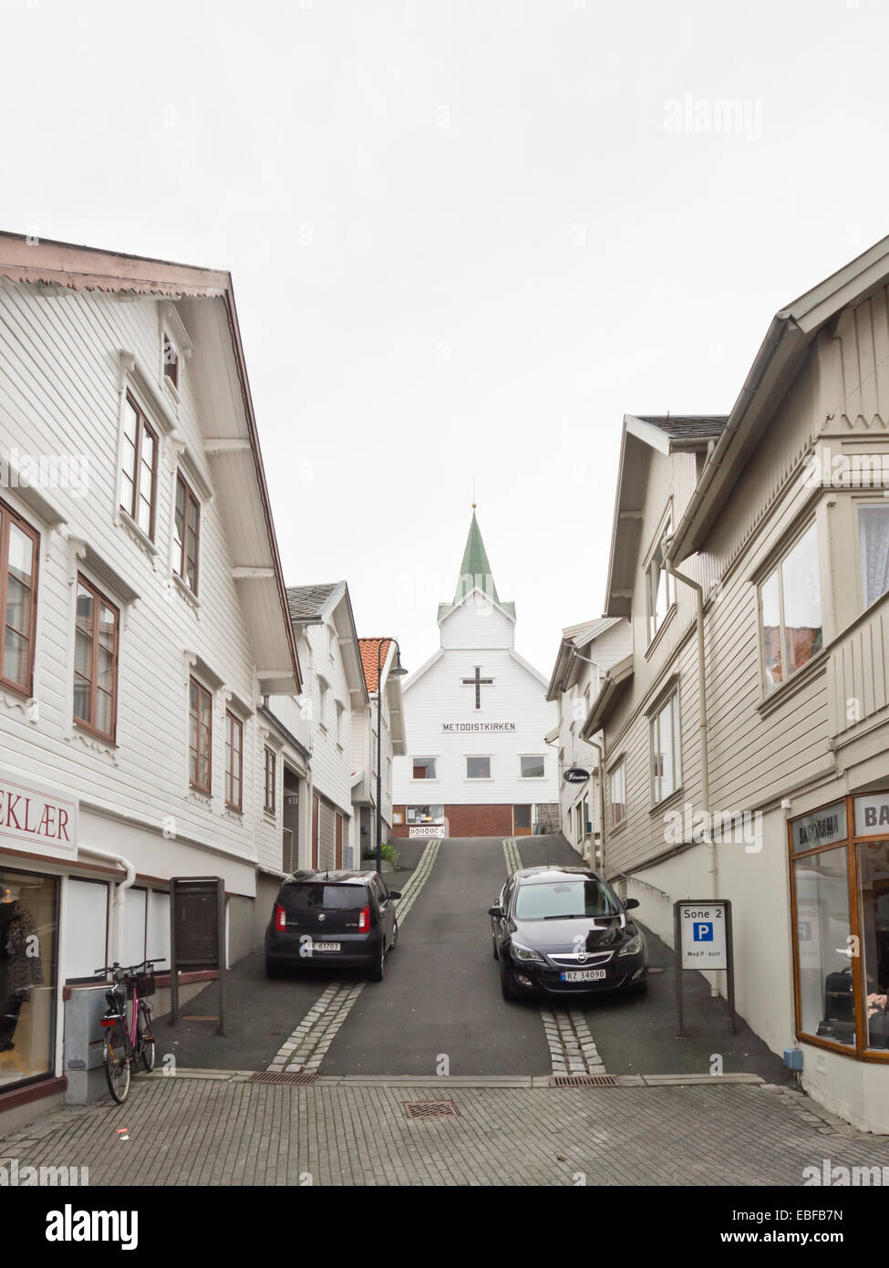 Street nel centro della piccola cittadina norvegese Egersund, pannellata in legno bianco case tradizionali e negozi chiesa metodista Foto Stock