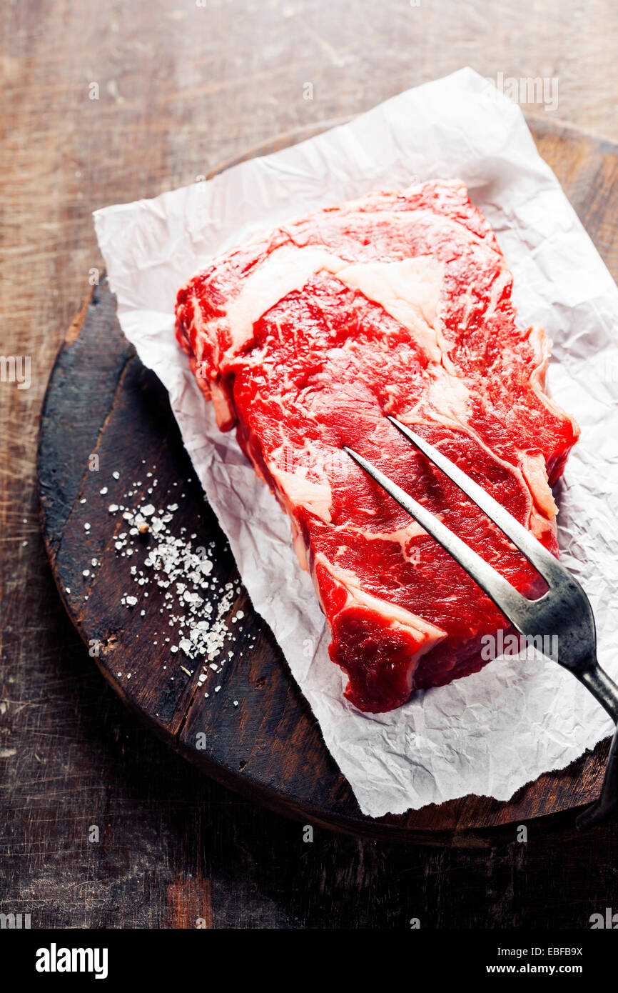 Materie bistecca con forcella di carne su un vecchio tavolo in legno Foto Stock