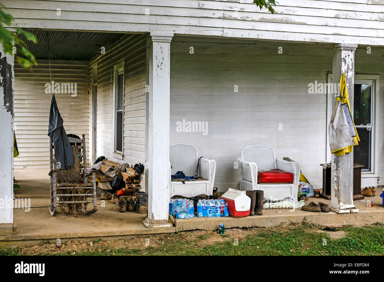 Una sedia a dondolo siede vuoto sotto il portico di tabacco di agricoltore e la casa rurale in Tennessee Foto Stock
