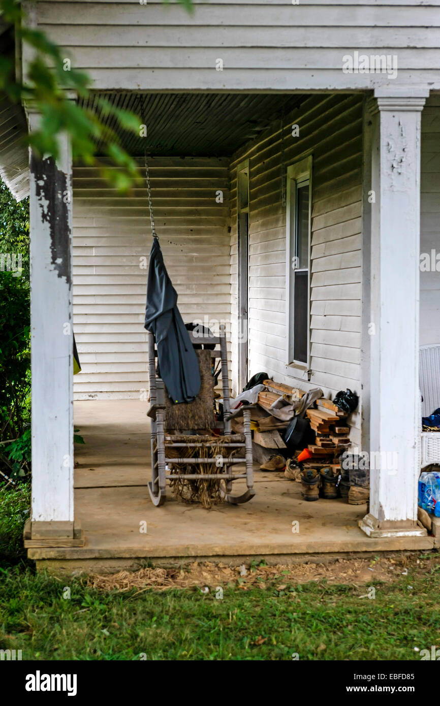 Una sedia a dondolo siede vuoto sotto il portico di tabacco di agricoltore e la casa rurale in Tennessee Foto Stock
