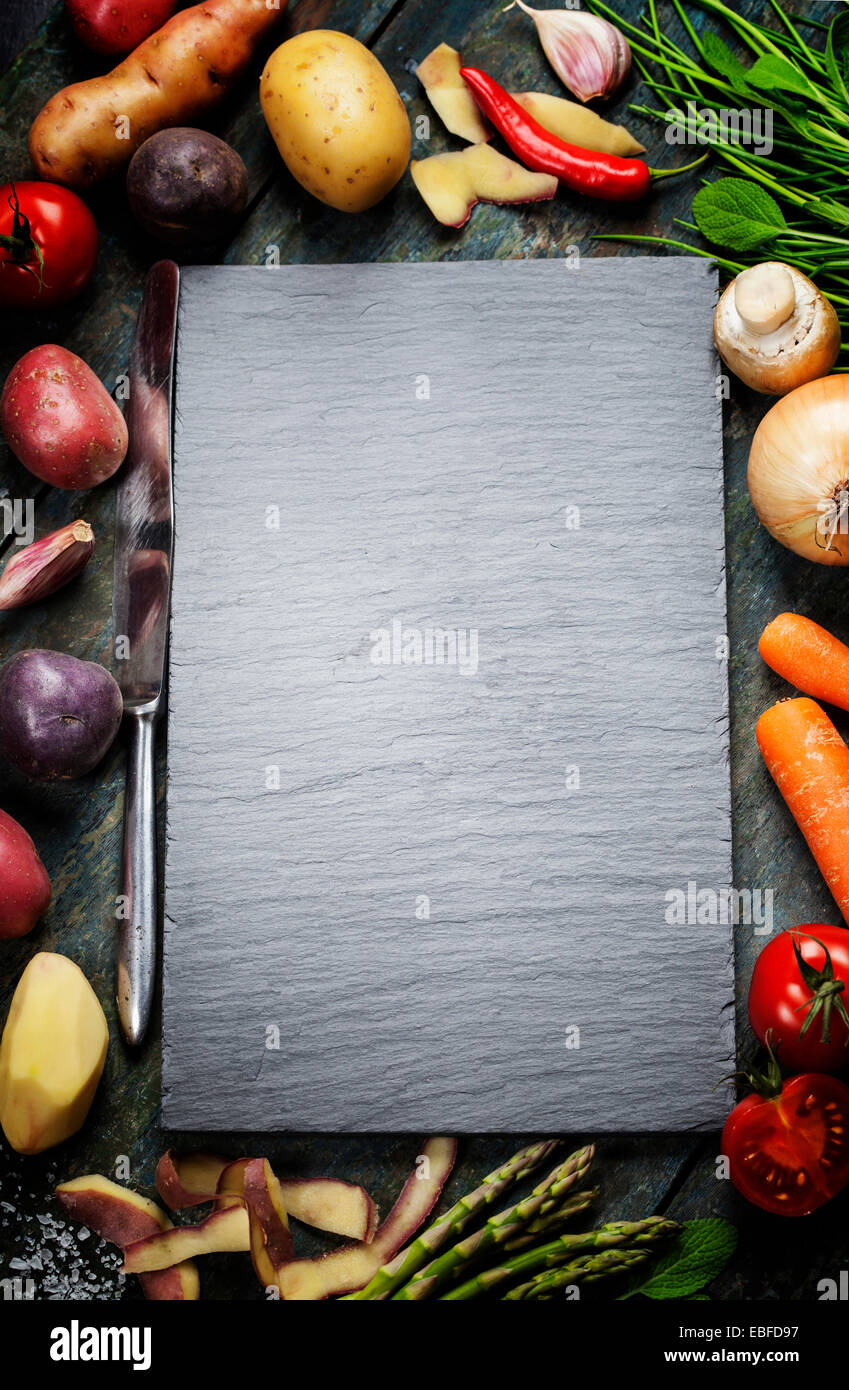 Sfondo di cibo, con verdure fresche. Ardesia e uno sfondo di legno. Foto Stock