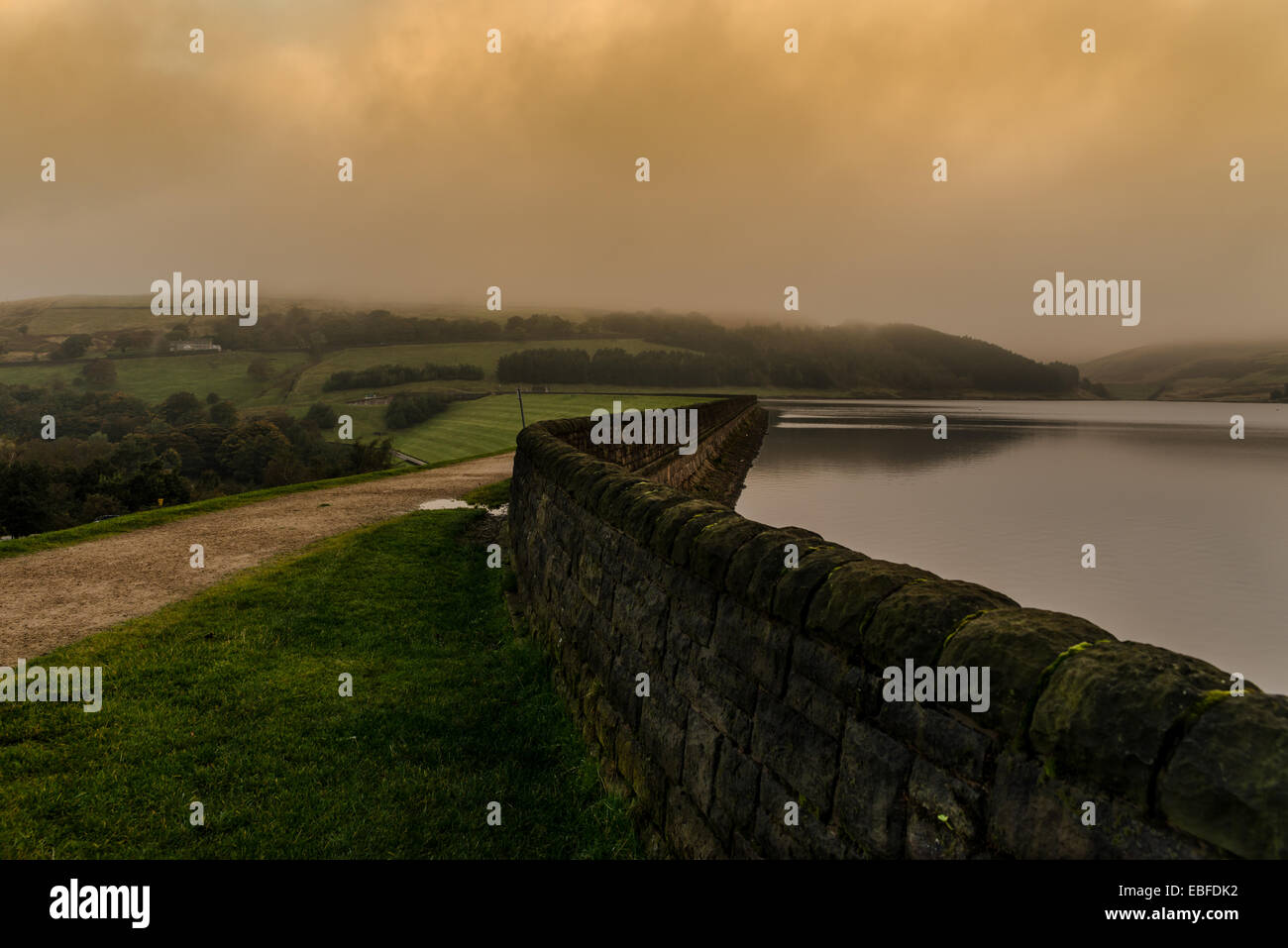 Golden nuvole come albe presto una mattina al serbatoio Dovestone, Parco Nazionale di Peak District Foto Stock