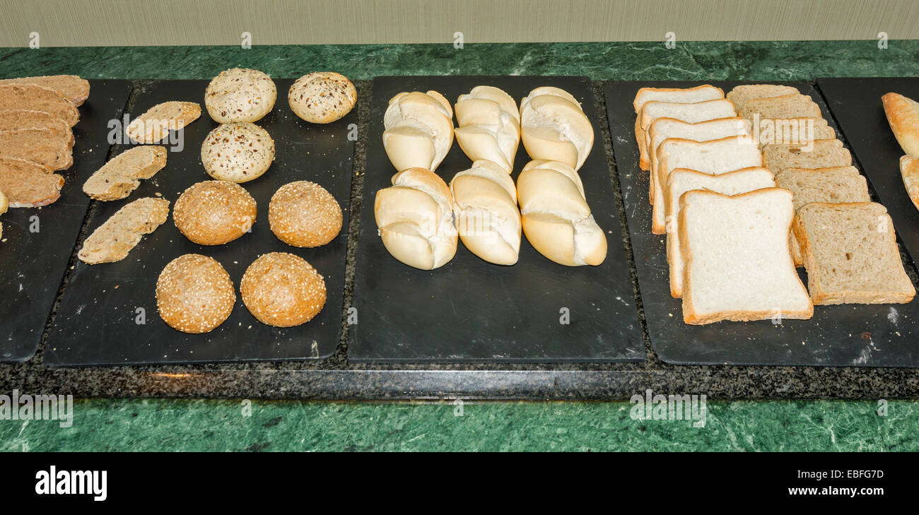 La prima colazione continentale di una selezione di seminate rotoli di pane e fette di pane bianco e integrale Foto Stock