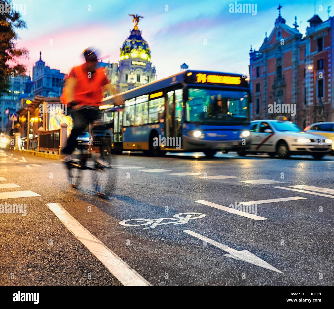 Ciclista presso la pista ciclabile di Alcalà‡ street con la metropoli edificio in background. Madrid, Spagna. Foto Stock