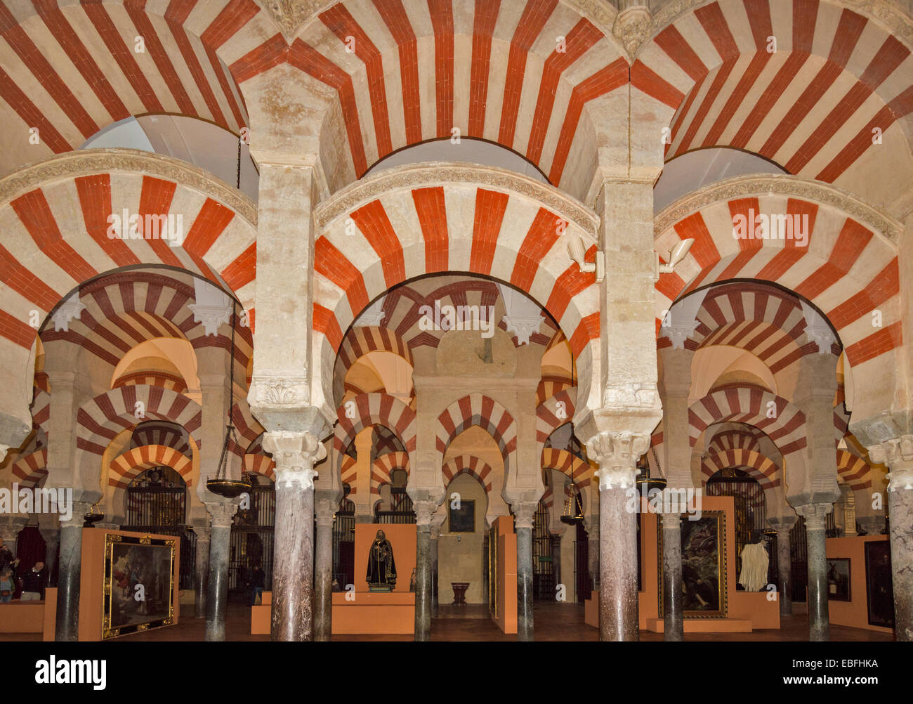 CORDOBA moschea Cattedrale Mezquita o file di colonne ed archi di pietra rossa guardando verso statue cristiane Foto Stock