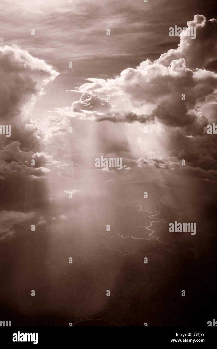 Alta altitudine nuvole, cumulus nubi in tonalità seppia, drammatica fotografia. La torsione di fiumi e torrenti in seguito in superficie. Foto Stock