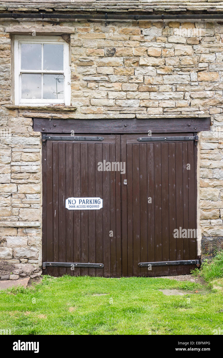 Nessun parcheggio avviso sulla porta del garage in Thwaite, North Yorkshire. Foto Stock