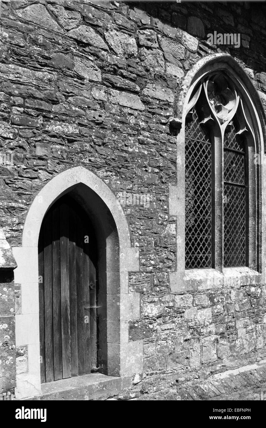 Parte di un antico villaggio chiesa parete contenente un portale ad arco e finestra con piombo. Foto Stock