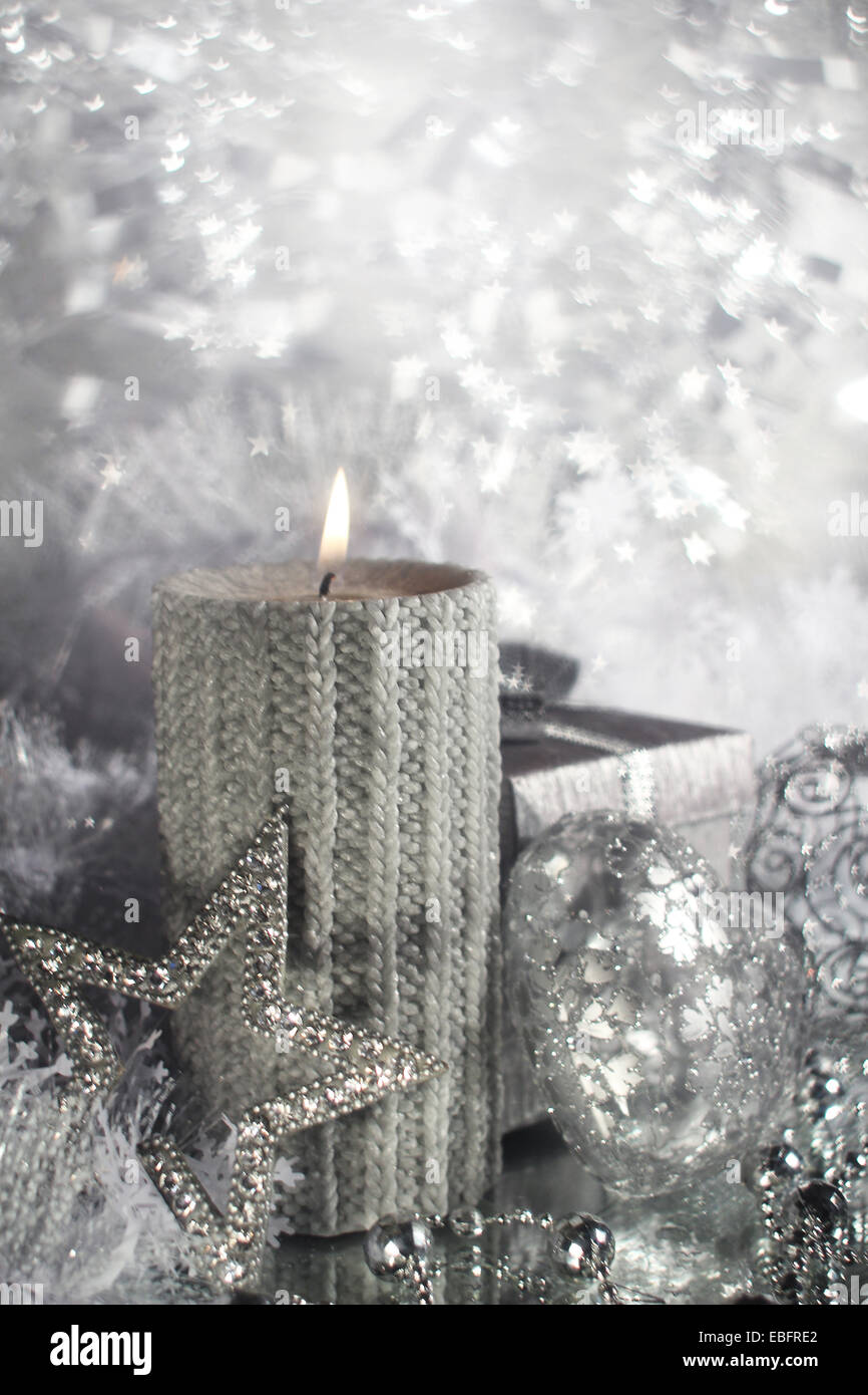 Bella argento lucido decorazioni di Natale e la candela che brucia Foto Stock