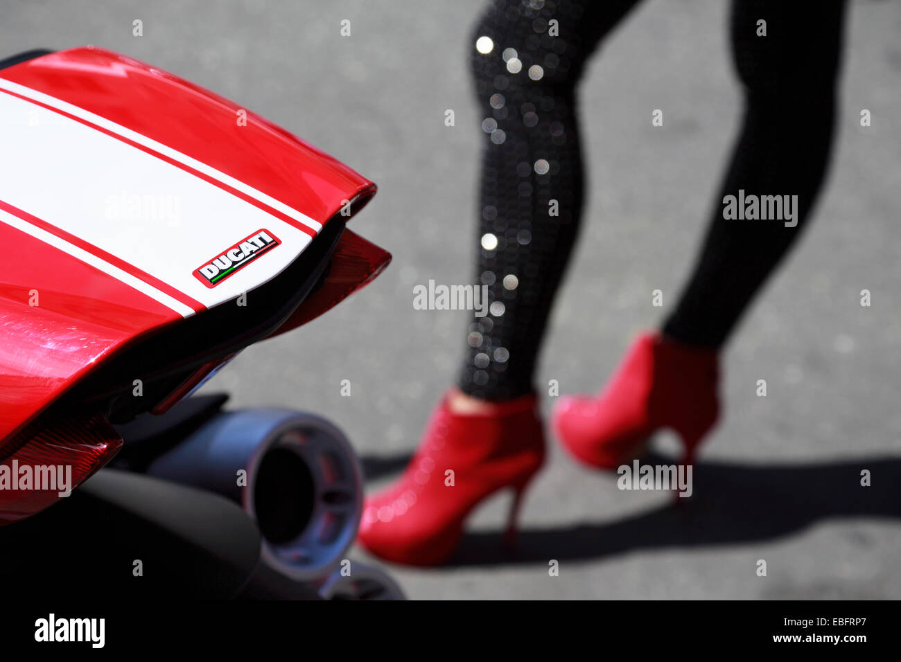 Moto Ducati dettaglio con una donna di gambe rosso da indossare tacchi alti  in background Foto stock - Alamy