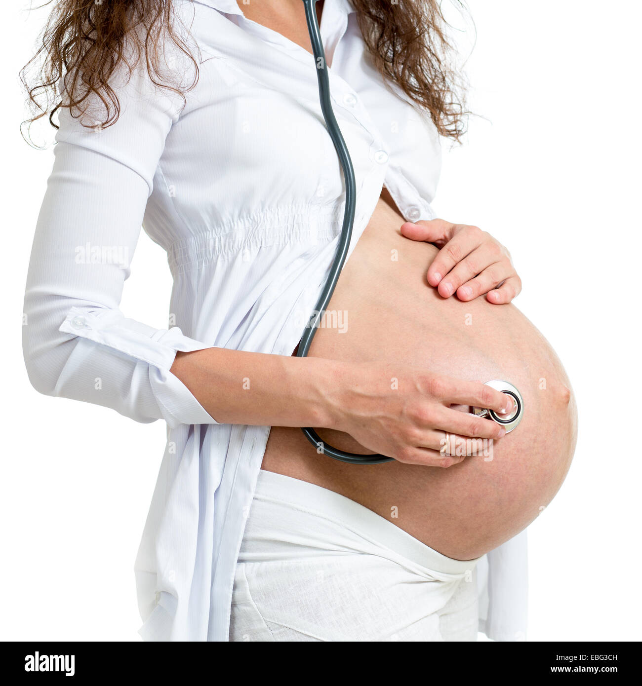 Donna incinta utilizzando uno stetoscopio per ascoltare i neonati i toni del cuore Foto Stock